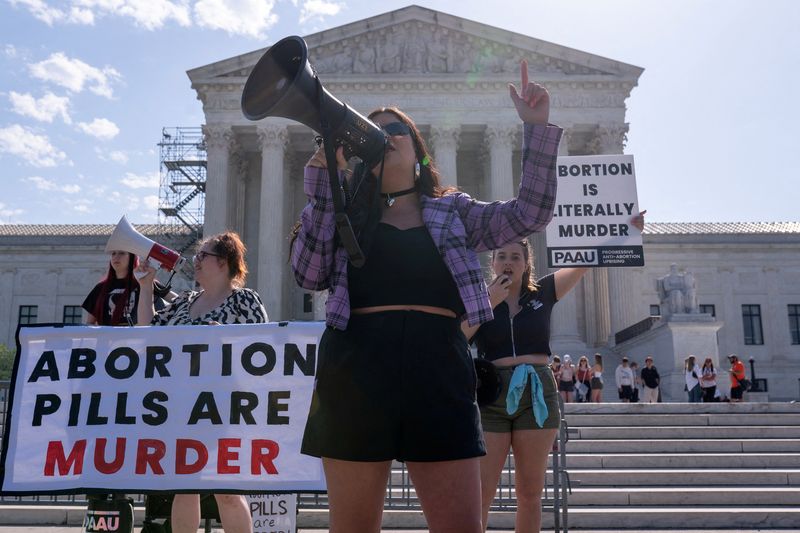 &copy; Reuters. FILE PHOTO: Anti-abortion activists hold signs calling for the Supreme Court justices to "affirm the decision of Federal District Court Judge Matthew Kacsmaryk who suspended the Food and Drug Administration's approval of Mifepristone," in front of the U.S