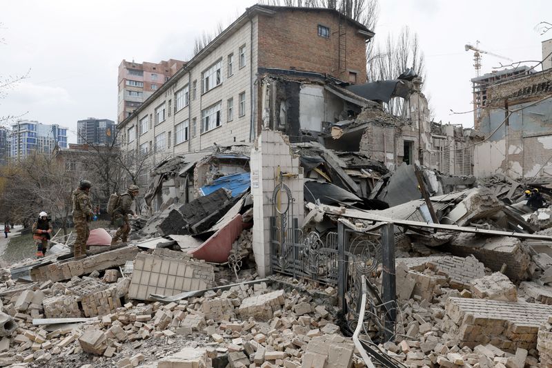 &copy; Reuters. عمال إنقاذ يعملوان في موقع لمبنى متضرر جراء القصف الروسي على أوكرانيا في كييف يوم الاثنين. تصوير: هليب هانيتش - رويترز.