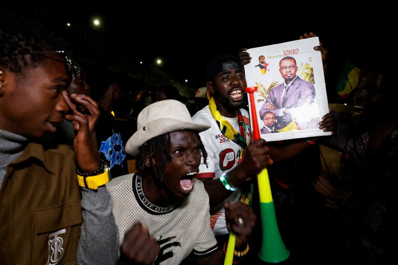 &copy; Reuters. FILE PHOTO: Supporters of Senegalese presidential candidate Bassirou Diomaye Faye celebrate early results showing that Faye is leading initial presidential election tallies, in Dakar, Senegal, March 24, 2024. REUTERS/Luc Gnago/File Photo