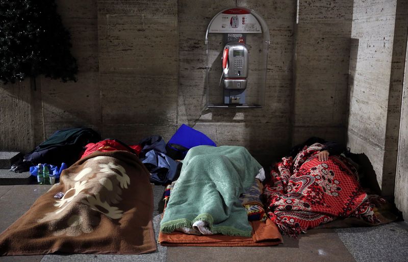 &copy; Reuters. أشخاص بلا مأوى ينامون في ممر بالقرب من ساحة القديس بطرس في روما بإيطاليا في صورة من أرشيف رويترز.
