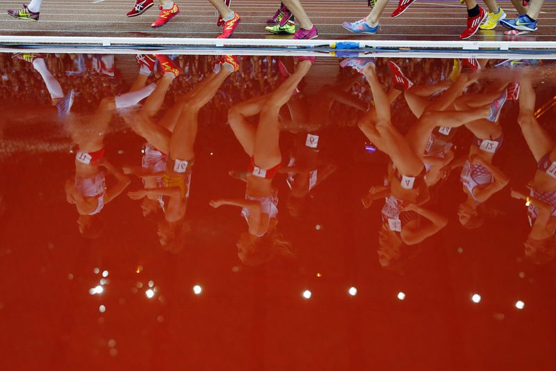 &copy; Reuters. FILE PHOTO: Runners are reflected in a puddle as they compete in the women's 5000m race at the 2014 Commonwealth Games in Glasgow, Scotland, August 2, 2014.      REUTERS/Phil Noble 