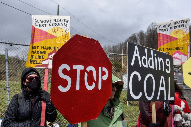 &copy; Reuters. FILE PHOTO: People hold signs as they protest against U.S. Senator Joe Manchin (D-WV) as they blockade the Grant Town Coal Waste Power Plant in Grant Town, West Virginia, U.S., April 9, 2022.  REUTERS/Stephanie Keith/File Photo