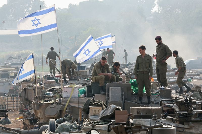 © Reuters. FILE PHOTO: Israeli soldiers stand on tanks, amid the ongoing conflict between Israel and the Palestinian Islamist group Hamas, near the Israel-Gaza border, in southern Israel, January 1, 2024. REUTERS/Violeta Santos Moura/File Photo