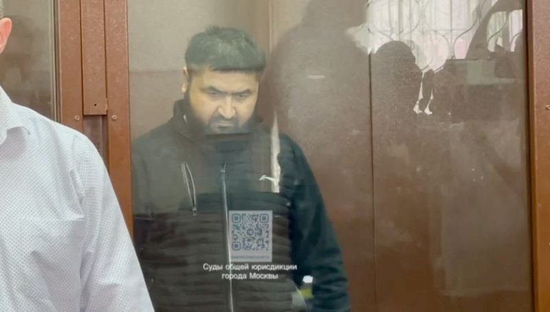 &copy; Reuters. Alisher Kasimov, a suspect in the Crocus City Hall attack charged with providing accommodation to the four men accused of carrying out shooting in the concert hall, sits behind a glass wall of an enclosure for defendants in a courtroom in Moscow, Russia, 