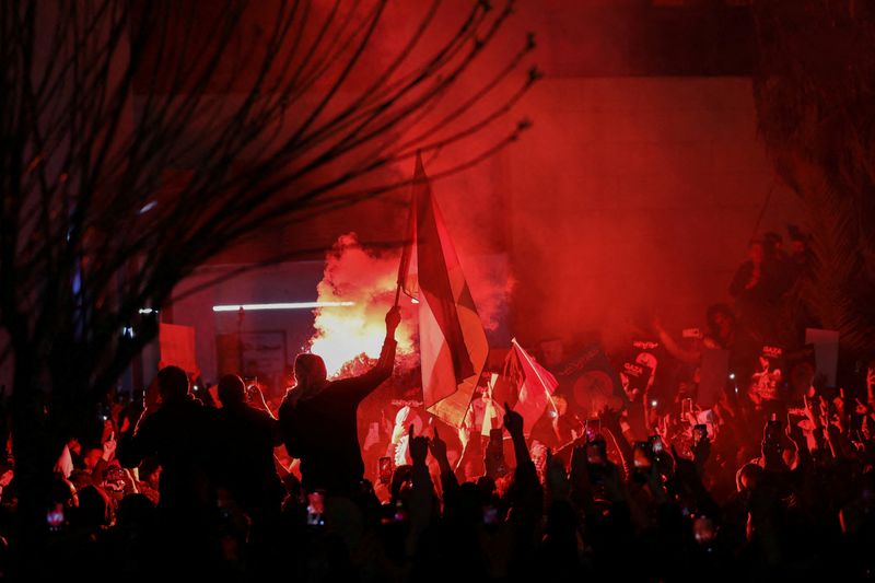 &copy; Reuters. Demonstrators carry banners and flags as a flare burns during a protest in support of Palestinians in Gaza, amid the ongoing conflict between Israel and the Palestinian Islamist group Hamas, outside Al Kalouti mosque near the Israeli embassy in Amman, Jor