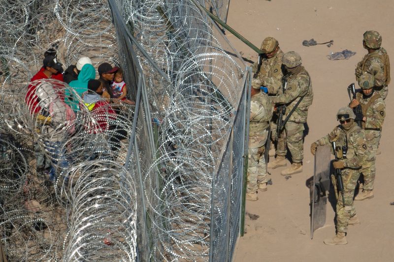 &copy; Reuters. FILE PHOTO: Members of the Army National Guard deter migrants attempting to cross into the U.S. past razor wire in El Paso, Texas, U.S., March 22, 2024. REUTERS/Adrees Latif/File Photo