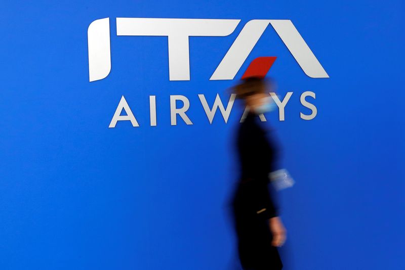 &copy; Reuters. A woman walks past the logo of the new state-owned Italian carrier Italia Trasporto Aereo at Fiumicino airport before a news conference to present the aircraft's new fleet, in Rome, Italy, March 1, 2022. REUTERS/Remo Casilli/File Photo