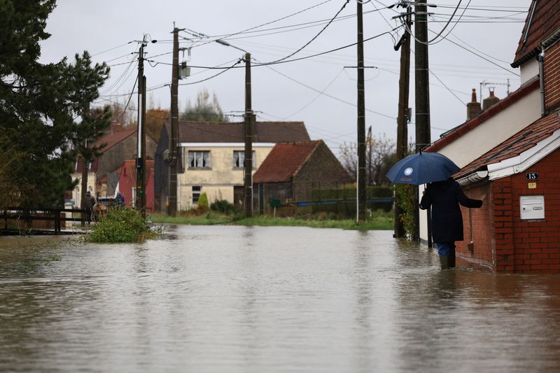 &copy; Reuters. Une femme marche dans une rue inondée du Doulac, dans le nord de la France. /Photo prise le 14 novembre 2023/REUTERS/Aurélien Morissard