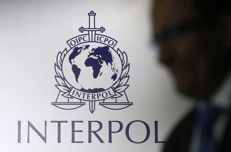 &copy; Reuters. Un homme passe devant un logo d'Interpol à Singapour. /Photo prise le 30 septembre 2014/REUTERS/Edgar Su