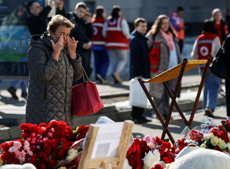 © Reuters. A woman reacts next to a makeshift memorial near the Crocus City Hall following a deadly attack on the concert venue in the Moscow Region, Russia, March 27, 2024. REUTERS/Maxim Shemetov