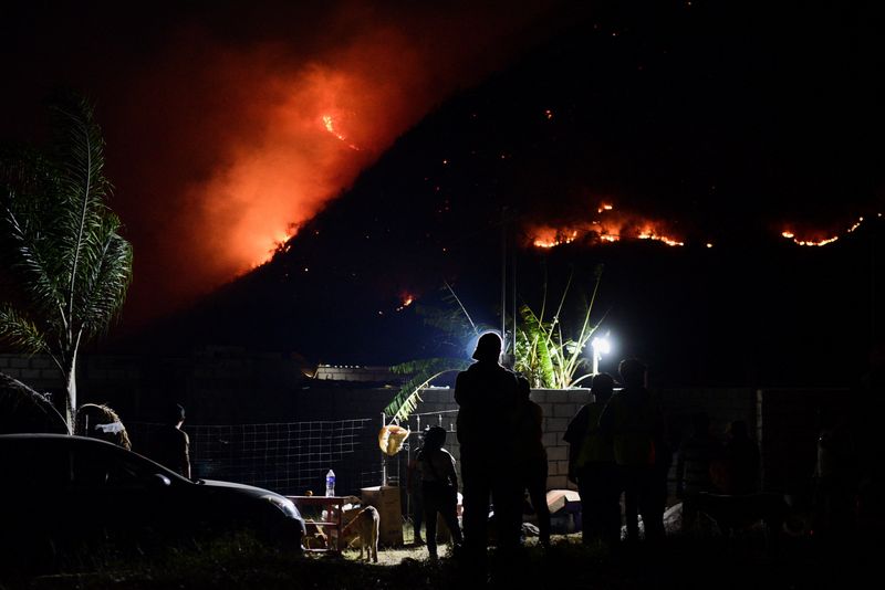 &copy; Reuters. Imagen de archivo. Ciudadanos observan cómo las llamas arden en la ladera de una montaña en medio de los incendios forestales en el estado Veracruz, en Nogales, México. 26 de marzo de 2024. REUTERS/Oscar Martínez