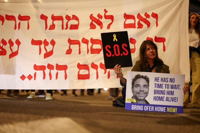© Reuters. Des manifestants brandissent des pancartes lors d'une manifestation demandant la libération des otages enlevés lors de l'attaque meurtrière du 7 octobre contre Israël par le groupe islamiste palestinien Hamas depuis Gaza, à Tel Aviv, Israë. /Photo prise le 27 mars 2024/REUTERS/Hannah McKay
