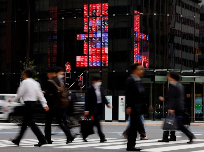&copy; Reuters. 　３月２８日、午前の東京株式市場で日経平均は、前営業日比４７９円２９銭安の４万０２８３円４４銭と、反落した。写真は株価ボードの前を通り過ぎる通行人。都内で昨年１０月撮影（