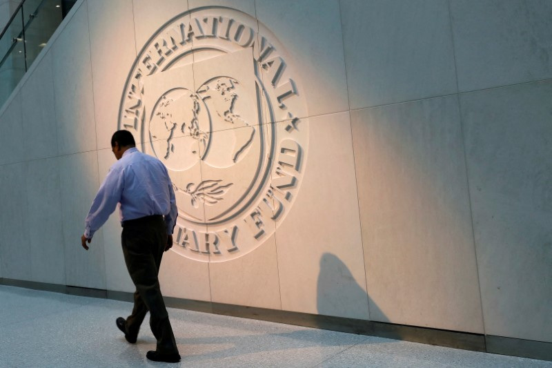 &copy; Reuters. FOTO DE ARCHIVO: Un hombre camina junto al logotipo del Fondo Monetario Internacional (FMI) en su sede en Washington, Estados Unidos. 10 de mayo de 2018. REUTERS/Yuri Gripas