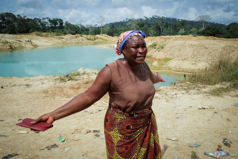© Reuters. Janet Gyamfi, agricultora de cacao de 52 años, reacciona mientras visita su plantación de cacao destruida por la minería ilegal de oro en la comunidad de Samreboi, en la región occidental de Ghana. 26 de febrero de 2024. REUTERS/Francis Kokoroko