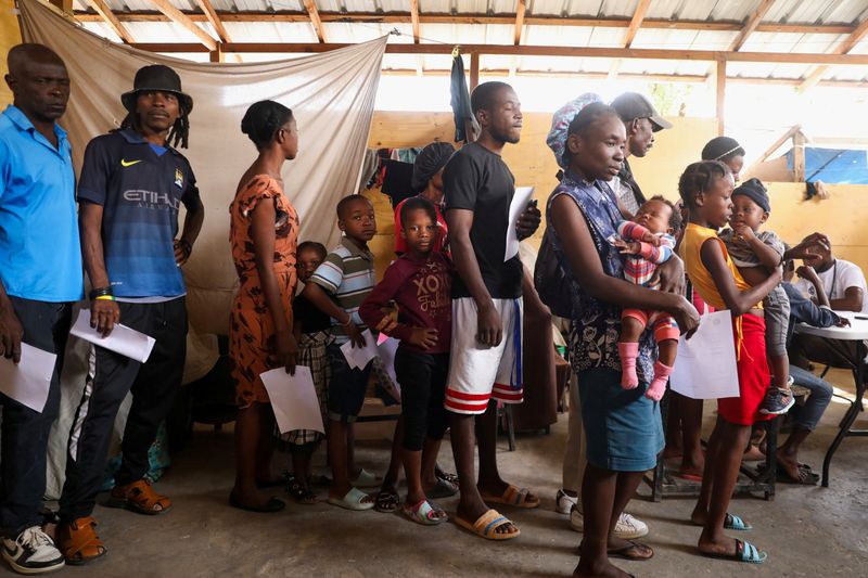 &copy; Reuters. Des personnes attendent d'être soignées par des agents de santé dans une clinique mobile organisée par l'UNICEF et Médecins du Monde pour les personnes déplacées par la violence des gangs, à Port-au-Prince, Haïti. /Photo prise le 26 mars 2024/REU