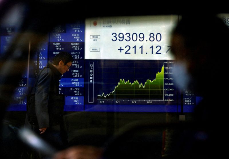 © Reuters. FILE PHOTO: An electronic screen displaying Japan's Nikkei share average and stock prices is seen through a car as the share average hits a record high in Tokyo, Japan February 26, 2024.  REUTERS/Issei Kato/File Photo