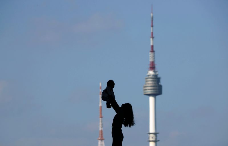 &copy; Reuters. A woman holding up her baby is silhouetted against the backdrop of N Seoul Tower, commonly known as Namsan Tower, in Seoul, South Korea, October 2, 2018.   REUTERS/Kim Hong-Ji/ File Photo