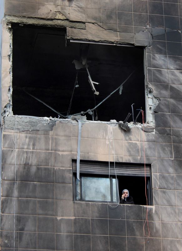 &copy; Reuters. Una mujer mira desde un edificio dañado después de que, según informan los medios estatales sirios, varios misiles israelíes impactaran contra un edificio residencial en el distrito de Kafr Sousa, Damasco, Siria. 21 de febrero de 2024. REUTERS/Firas M