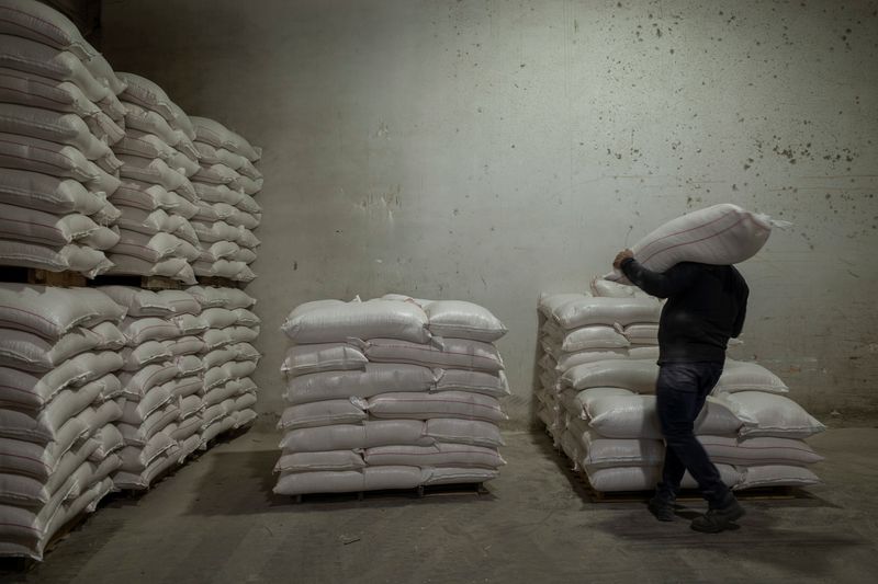 © Reuters. FILE PHOTO: A worker carries a bag of animal feed at the Union of Agricultural Cooperatives on the island of Naxos, Greece, May 16, 2022. REUTERS/Karolina Tagaris/File Photo