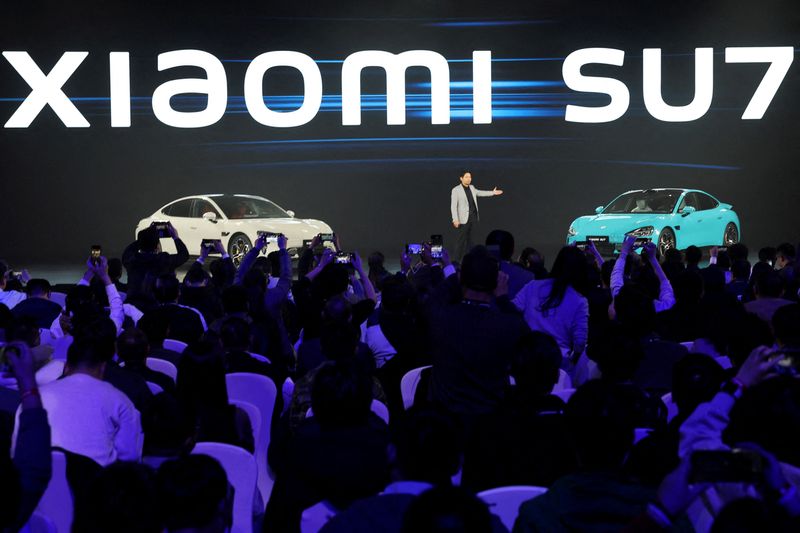 &copy; Reuters. FOTO DE ARCHIVO. El fundador y presidente ejecutivo de Xiaomi, Lei Jun, junto al primer vehículo eléctrico recientemente presentado por Xiaomi, el SU7, en un evento en Pekín, China, el 28 de diciembre de 2023. REUTERS/Florence Lo