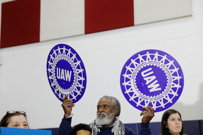 © Reuters. FILE PHOTO: A man holds United Auto Workers (UAW) signs in Dearborn, Michigan, U.S. March 7, 2020. REUTERS/Lucas Jackson/File Photo