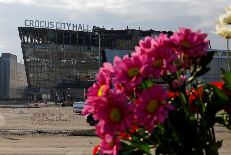 &copy; Reuters. A view through flowers shows the burnt-out Crocus City Hall following a deadly attack on the concert venue outside Moscow, Russia, March 29, 2024. REUTERS/Evgenia Novozhenina