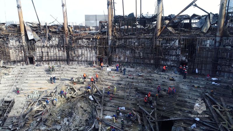 © Reuters. Members of the Russian Emergencies Ministry and workers remove debris inside the burnt-out Crocus City Hall following a deadly attack on the concert venue outside Moscow, Russia, in this still image taken from video released March 26, 2024. Russian Emergencies Ministry/Handout via REUTERS