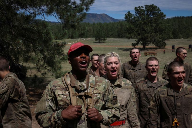 © Reuters. Marcus Berrette cheers on his fellow cadets as they complete the assault course, a grueling obstacle course that is meant to simulate many facets of a combat zone, in Jacks Valley during the field portion of their basic training at the U.S. Air Force Academy in Colorado Springs, Colorado, U.S., July 15, 2022. REUTERS/Kevin Mohatt