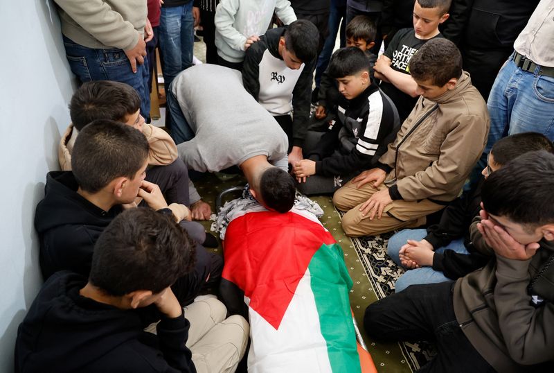 © Reuters. أحد المشيعين يقبل جثمان الفتى الفلسطيني معتصم كميل (13 عاما) ، خلال جنازته عقب مقتله على يد القوات الإسرائيلية بالرصاص خلال مداهمة في بلدة قباطية جنوبي مدينة جنين بالضفة الغربية يوم السبت . تصوير: رنين صوافطة - رويترز 