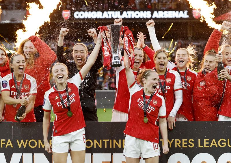 &copy; Reuters. Soccer Football -  FA Women's League Cup - Final - Arsenal v Chelsea - Molineux Stadium, Wolverhampton, Britain - March 31, 2024 Arsenal's Leah Williamson and Kim Little lift the trophy as they celebrate with teammates after winning the League Cup Action 