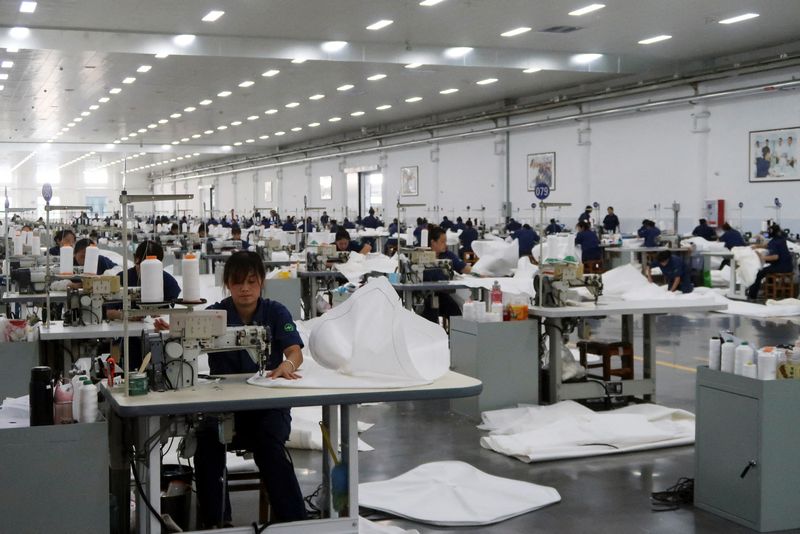 © Reuters. FOTO DE ARCHIVO: Empleados trabajan en la línea de producción de telas filtrantes en la fábrica de filtros prensa Jingjin en Dezhou, provincia de Shandong, China 25 de agosto de 2022. REUTERS/Siyi Liu/Foto de archivo 