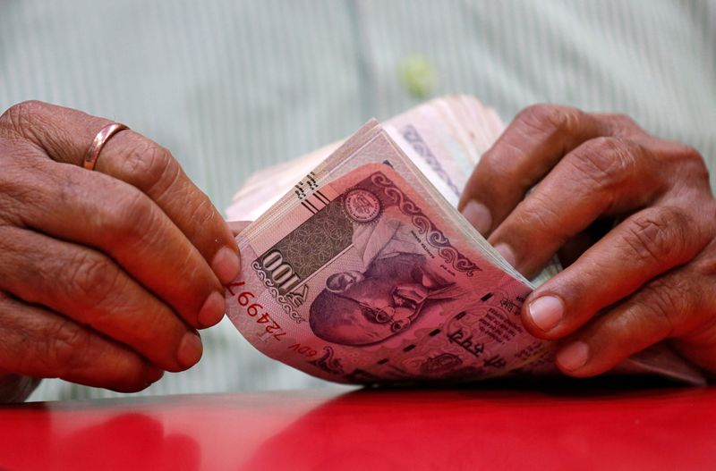 © Reuters. A man counts Indian currency notes inside a shop in Mumbai, India, August 13, 2018. REUTERS/Francis Mascarenhas/File Photo