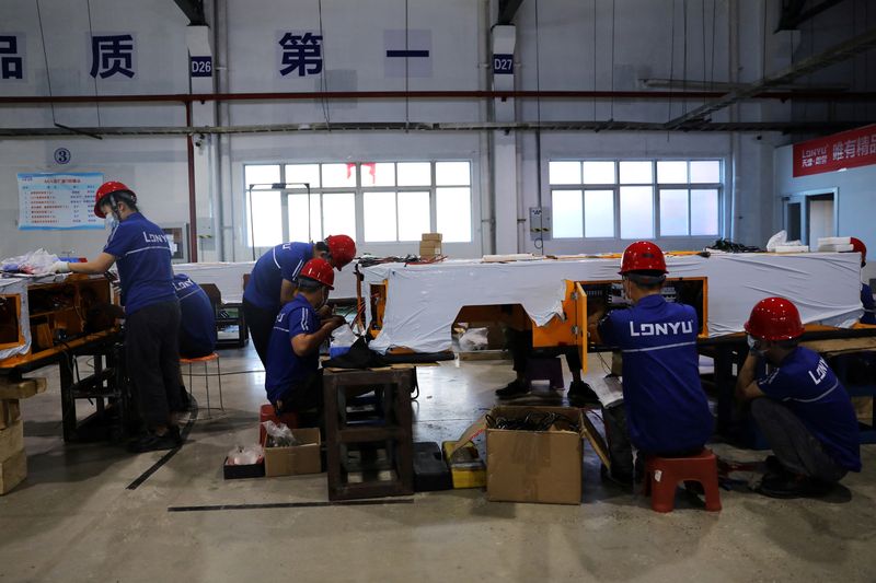 &copy; Reuters. FILE PHOTO: Employees work on assembling automated guided vehicles (AGV) at a Lonyu Robot Co factory in Tianjin, China, September 7, 2021. Picture taken September 7, 2021. REUTERS/Tingshu Wang/File Photo