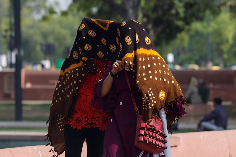 © Reuters. Mulheres se abrigam do sol em Nova Delhi
15/05/2023
REUTERS/Anushree Fadnavis