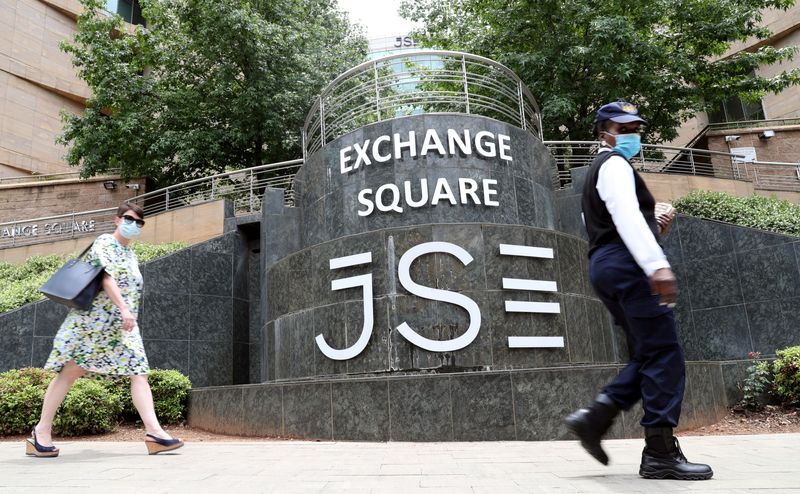 &copy; Reuters. FILE PHOTO: People wearing face masks walk past the Johannesburg Stock Exchange in Sandton, South Africa,  November 9, 2020. REUTERS/Siphiwe Sibeko/File Photo