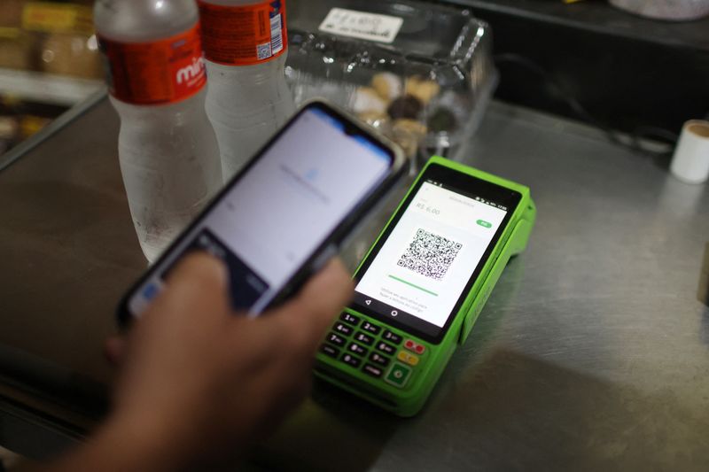 © Reuters. A person pays using their cell phone with the instant electronic payment mode known as PIX, at a store in Rio de Janeiro, Brazil April 1, 2024. REUTERS/Pilar Olivares