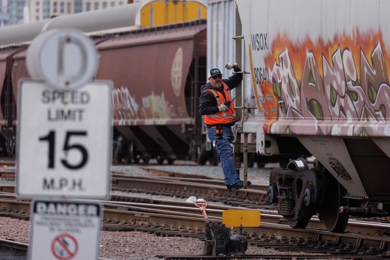 &copy; Reuters. FILE PHOTO: A railway worker helps load railcars onto a train in San Diego, California, U.S., November 30, 2022. REUTERS/Mike Blake/File Photo