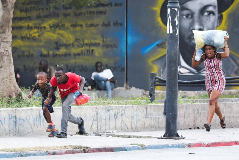 &copy; Reuters. Foto de Archivo: Personas se protegen de los disparos cerca del Palacio Nacional, en Puerto Príncipe, Haití, el 21 de marzo de 2024. REUTERS/Ralph Tedy Ero