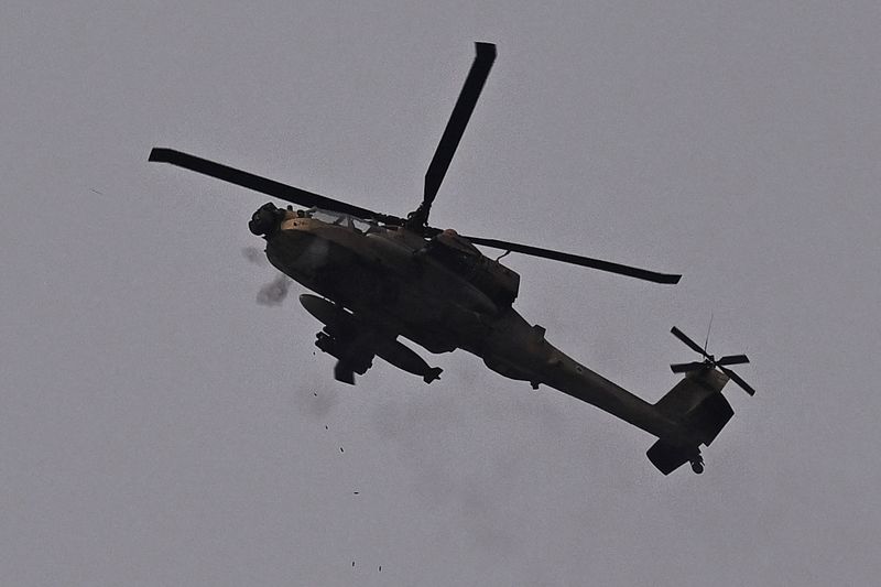 &copy; Reuters. Un hélicoptère d'attaque AH-64 Apache de l'armée de l'air israélienne tire avec sa mitrailleuse près de la frontière de Gaza, dans le cadre du conflit entre Israël et le groupe islamiste palestinien Hamas, vu d'Israël. /Photo prise le 12 février 