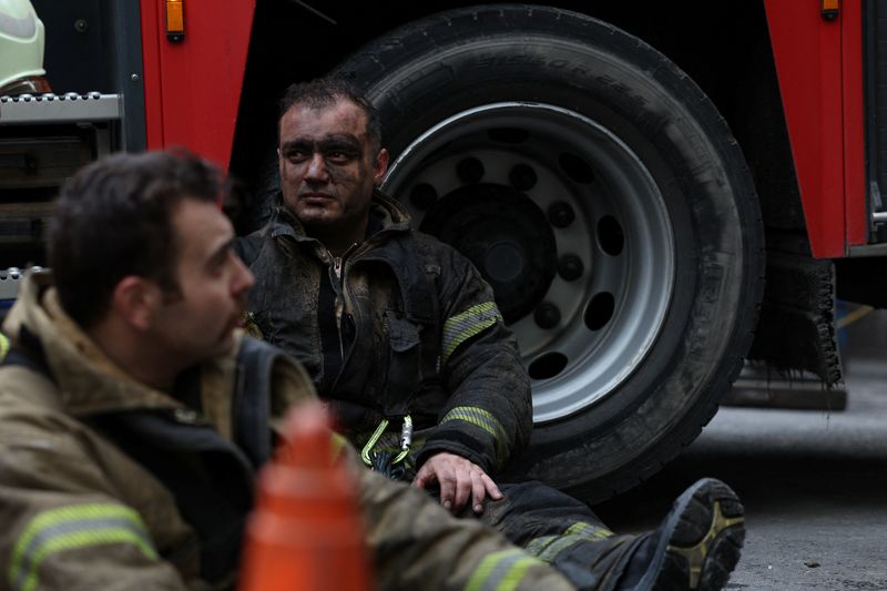 © Reuters. رجال إطفاء يلتقطون أنفاسهم في موقع مبنى اندلعت فيه النيران خلال إصلاحات في أثناء  النهار داخل ملهى ليلي في إسطنبول يوم الثلاثاء. تصوير: مراد سيزار - رويترز
