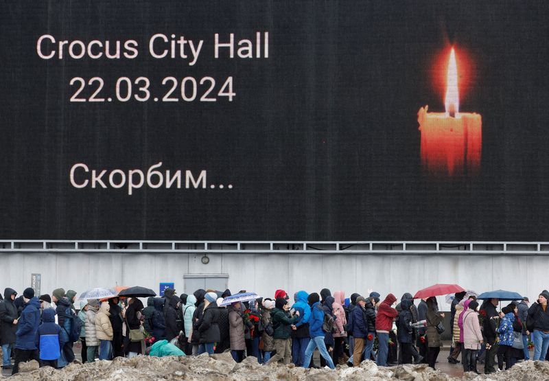 &copy; Reuters. أشخاص يصطفون لوضع أكاليل الزهور عند نصب تذكاري مؤقت لضحايا هجوم بإطلاق النار خارج قاعة كروكوس سيتي في منطقة موسكو يوم 24 مارس آذار 2024. تصوير: 