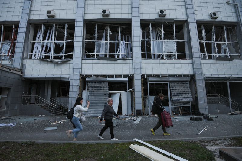 &copy; Reuters. FOTO DE ARCHIVO: Un grupo de personas camina frente al edificio de una universidad deportiva dañado durante un ataque con misiles rusos, en medio del ataque de Rusia a Ucrania, en Dnipró, Ucrania. 2 de abril de 2024. REUTERS/Mykola Synelnykov