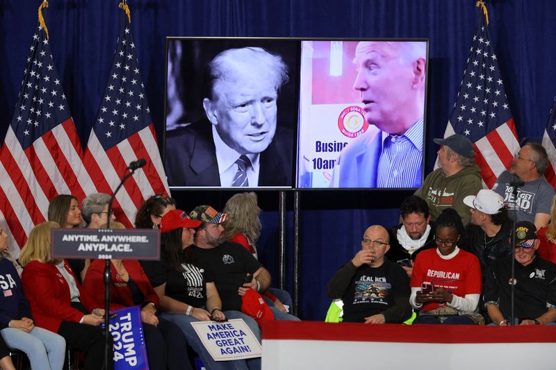 &copy; Reuters. Pictures of U.S. President Joe Biden and Republican presidential candidate and former U.S. President Donald Trump are seen on a screen during campaign rally for Trump in Green Bay, Wisconsin, U.S., April 2, 2024. REUTERS/Brian Snyder