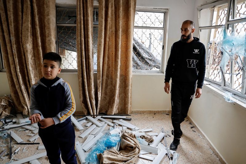 &copy; Reuters. رجل وطفل فلسطينيان يتفقدان غرفة مدمرة داخل منزل تعرض لقصف خلال هجوم صاروخي عقب غارة إسرائيلية على جنين بالضفة الغربية المحتلة في يوم 27 مارس 