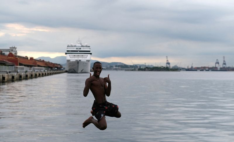 &copy; Reuters. FILE PHOTO: A youth jumps into the waters of Guanabara Bay, next to a cruise ship docked at Rio de Janeiro port, in Rio de Janeiro, Brazil, March 17, 2020. REUTERS/Ricardo Moraes/File Photo