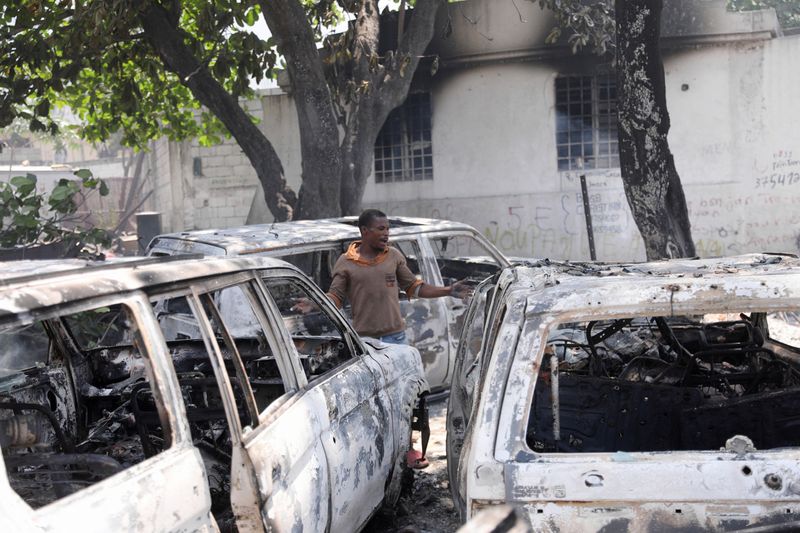 &copy; Reuters. FILE PHOTO: A man reacts next to the charred remains of vehicles near the presidential palace, after they were set on fire by gangs, as violence spreads and armed gangs expand their control over the capital, in Port-au-Prince, Haiti, March 25, 2024. REUTE