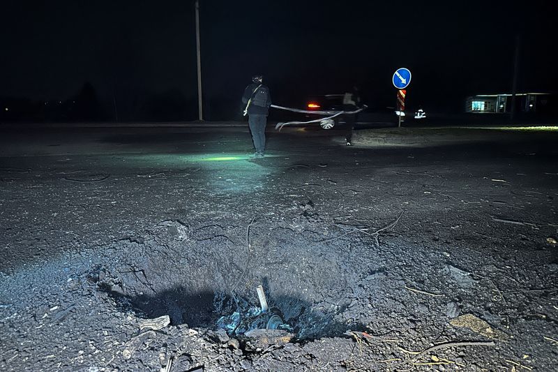 © Reuters. FOTO DE ARCHIVO: Agentes de policía trabajando junto a un cráter aparecido tras el ataque de un dron ruso, en medio del ataque de Rusia a Ucrania, en Járkov, Ucrania. 26 de marzo de 2024. REUTERS/Vitalii Hnidyi