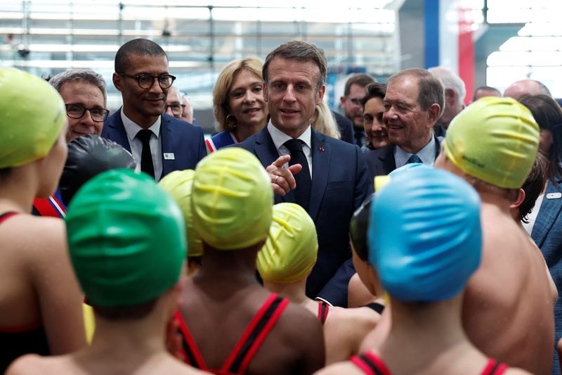 &copy; Reuters. French President Emmanuel Macron talks to children after their swimming performance during the inauguration of the Olympic Aquatics Centre (CAO), a multifunctional venue for the 2024 Paris Olympic Games construction site which is under the management of t
