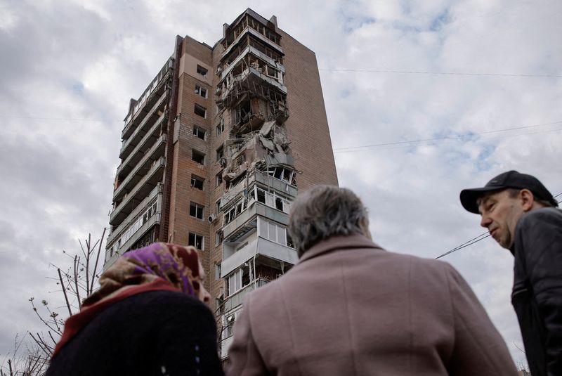 © Reuters. Local residents stand in a front of an apartment building hit by a Russian drone strike, amid Russia's attack on Ukraine, in Kharkiv, Ukraine April 4, 2024. REUTERS/Yevhen Titov